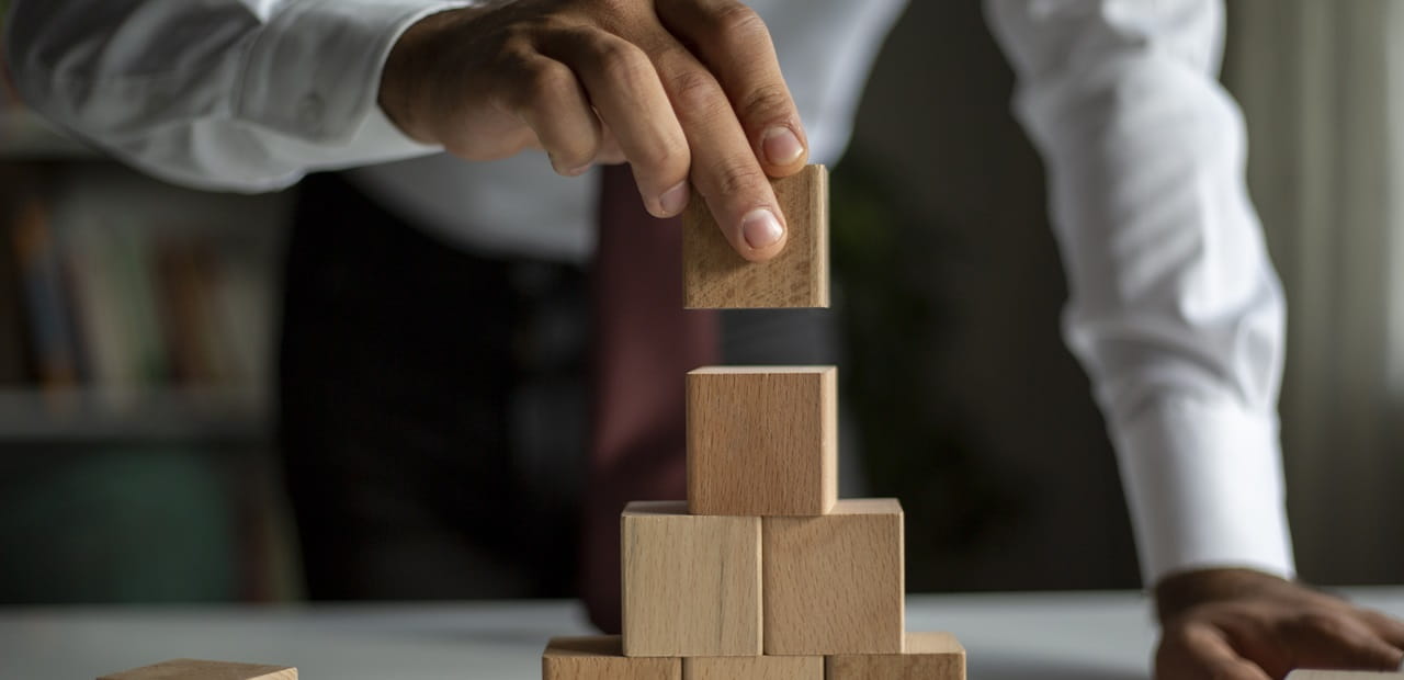 Businessman stacking building blocks representing business concept growth success process.