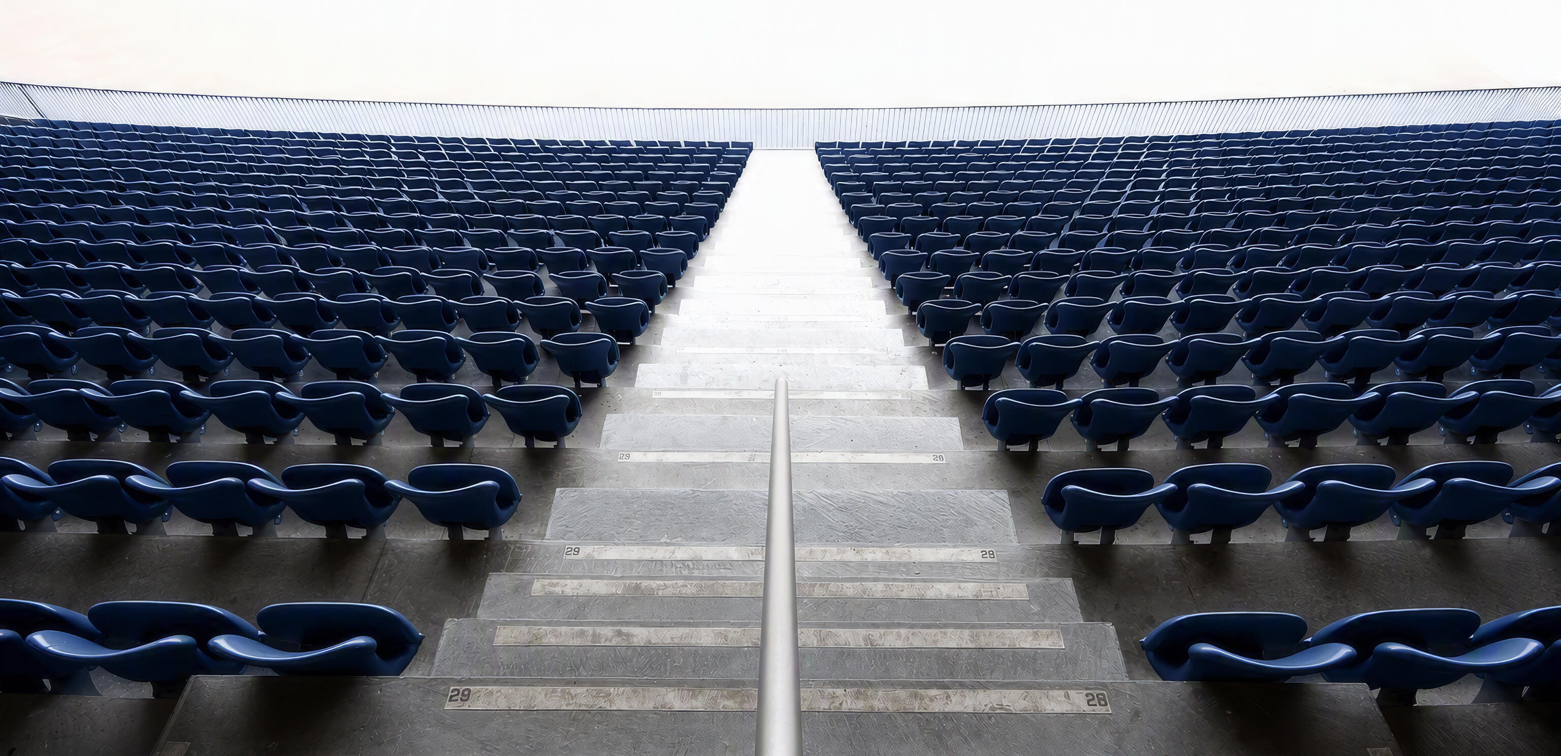 Empty stadium seating symbolizes the inverted wealth lifecycle of professional athletes, who often earn peak income early in life and must sustain it long after their playing careers end.