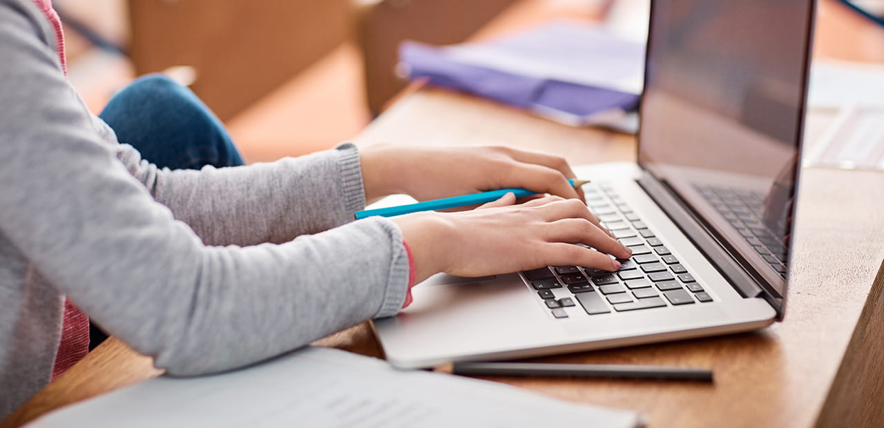 Child using a laptop while learning safe online habits.