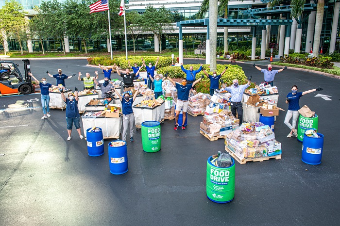 Raymond James associates practice social distancing while volunteering to unload donations.