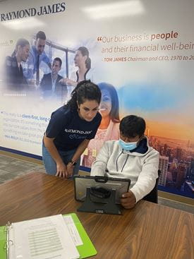 Alexa Grossenbach helps a student on his iPad