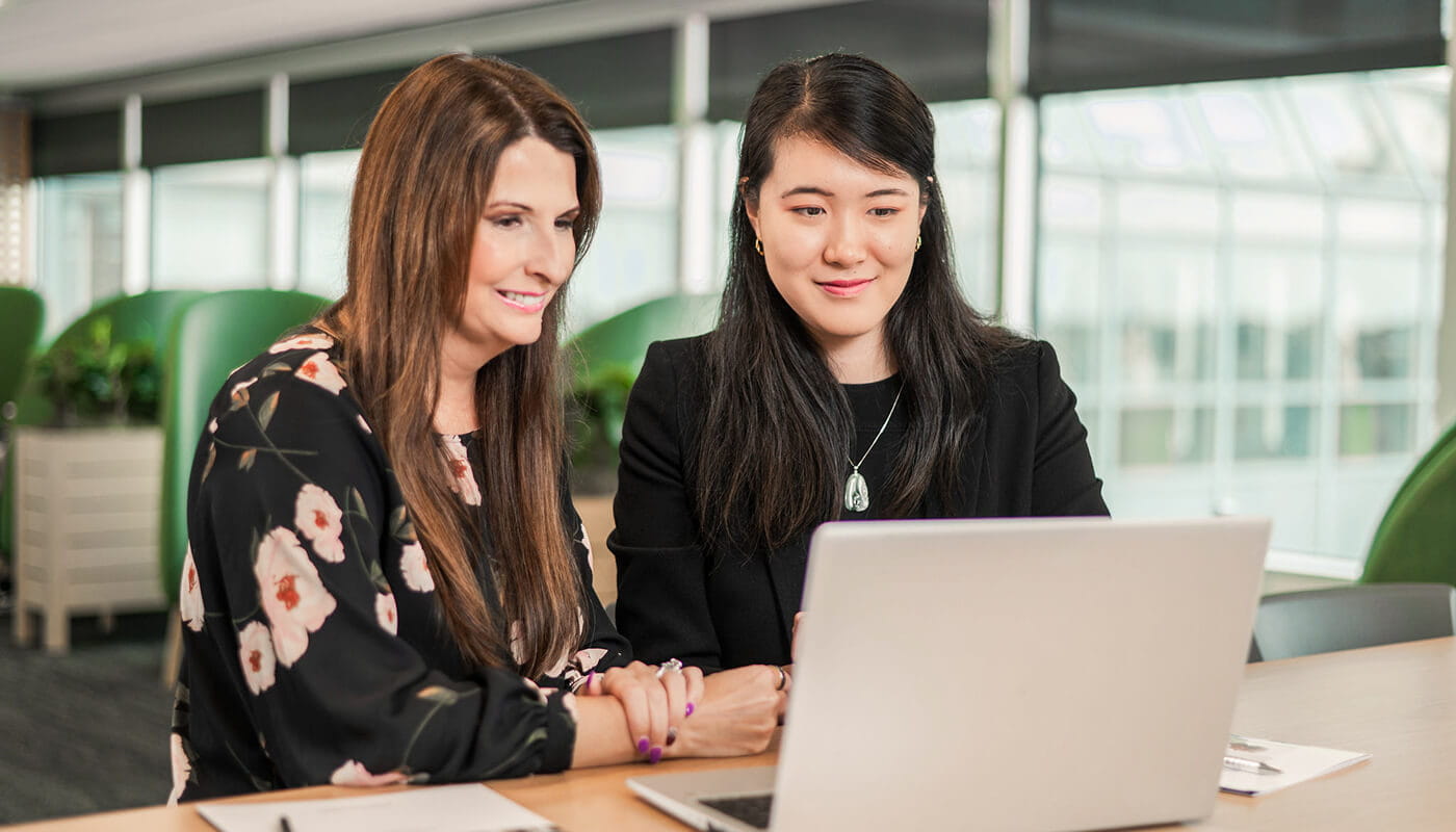 Associates working at Raymond James at laptop