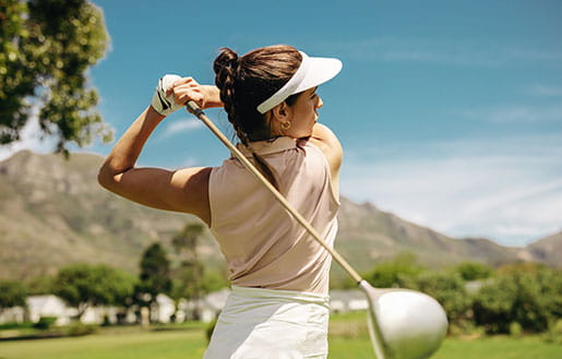Female golfer executing a perfect swing with a driver club